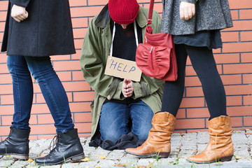 People passing by the homeless person