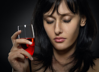 beautiful woman crying with a glass of red wine