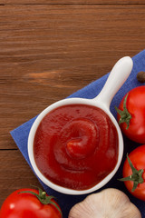 tomato sauce in bowl on wood