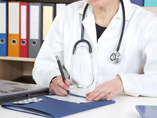 Doctor writes prescription for patients