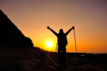cheeering woman hiker on sunrise seaside 