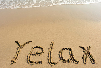 relax word drawn on beach