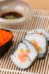 sushi and soy sauce on bamboo mat