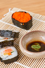 sushi and soy sauce on bamboo mat
