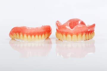 A set of dentures on a shiny white background