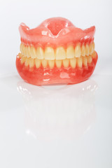 A set of dentures on a shiny white background