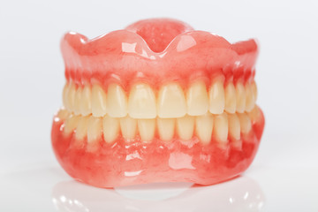 A set of dentures on a shiny white background