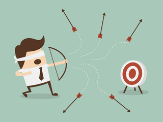 Blindfold businessman shooting arrow