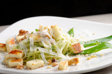 Pasta spaghetti with pesto sauce, walnuts and goat cheese