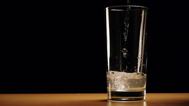 Water is slowly poured into a glass