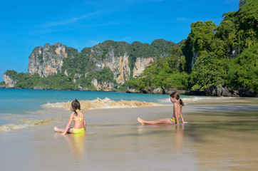 Obraz premium Happy girls play in sea on tropical beach