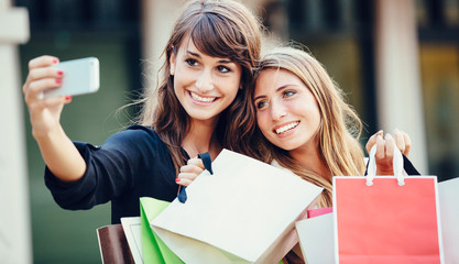 Two young women shopping at the mall taking a 