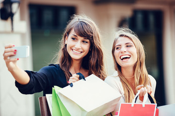 Two young women shopping at the mall taking a 