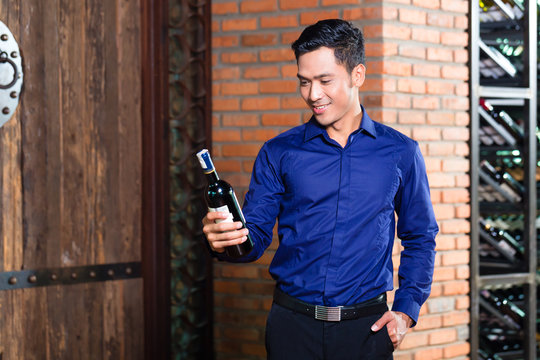 Asian Man Holding Bottle Of Wine