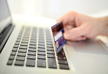 Man holding credit card in hand online shopping and banking