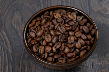 bowl of coffee beans on a dark background, close-up