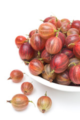 red gooseberries in a bowl isolated on white, close-up