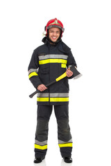 Fototapeta premium Firefighter posing with axe. Front view.