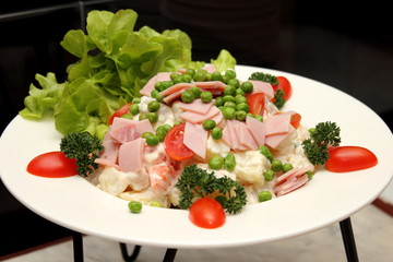 Green salad topped with sliced ham