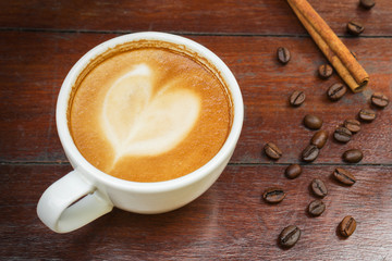 Coffee cup and beans on wooden table