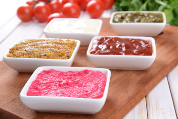 Various sauces on chopping board on table close-up