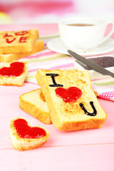 Delicious toast with jam and cup of tea on table close-up