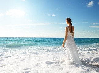 Fototapeta na wymiar young woman standing in sea waves