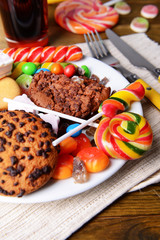 Different sweets on plate on table close-up