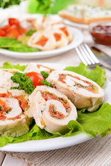Delicious chicken roll on plate on table close-up