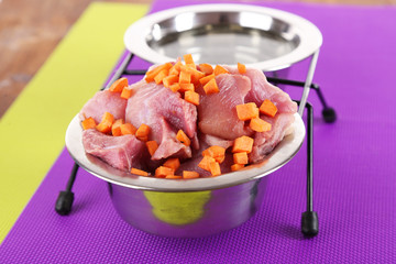 Natural food for pets and water in bowls on floor