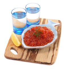 Red caviar in bowl and vodka on wooden board isolated on white