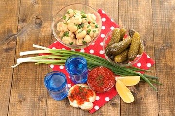 Composition with glass of vodka and marinated mushrooms,