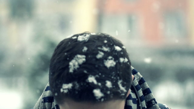 Sick teenage boy sneezing in snowy weather, super slow motion