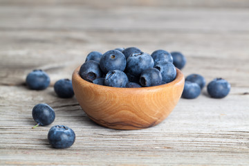 bowl of blueberries on wooden background