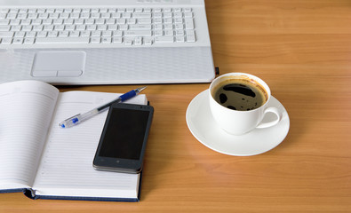 Workplace, laptop and notepad on table.