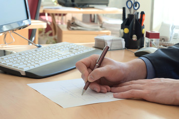 Man writes something on a white paper. Office work