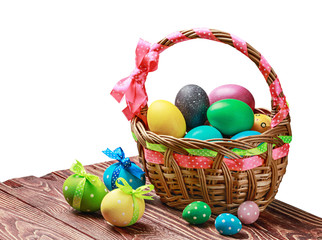 painted eggs in a basket on a table on a white