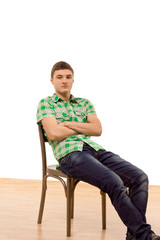 Confident young man sitting comfortably in a chair