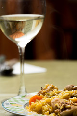 Traditional Spanish food, rice with rabbit and wine glass