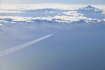 Airplane airline overflying ocean and volcanic island