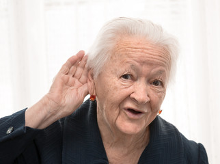 Portrait of old woman putting hand to her ear
