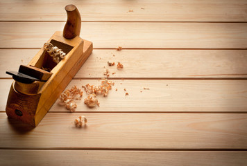 Carpenter's plane on wooden background