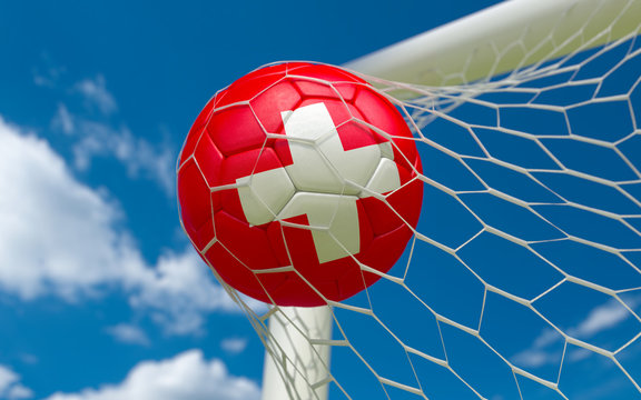Switzerland flag and soccer ball in goal net