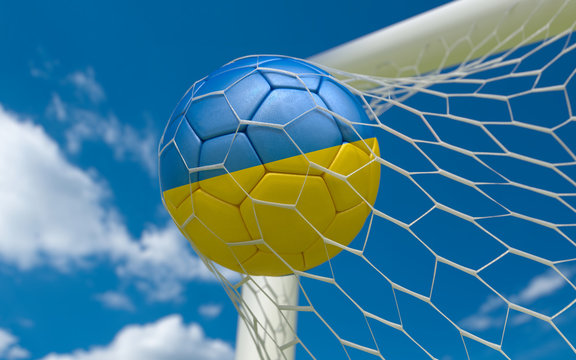 Ukraine flag and soccer ball in goal net