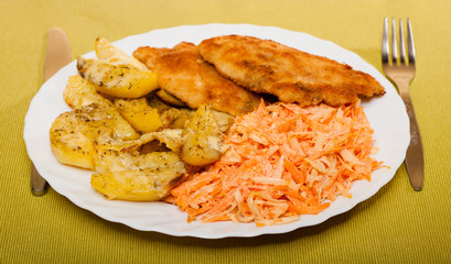 Dinner meal. Fried chicken roasted potatos and carrot salad.