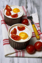Baked eggs on wooden table close up