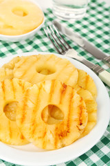 Juicy grilled pineapple on plate on table close-up