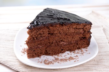 Delicious chocolate cake on plate on table close-up