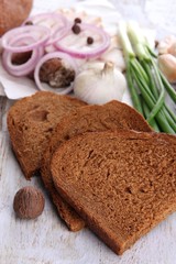 Slices of bread and lard with onion on cutting board close up