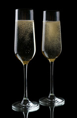 Glasses of champagne, on black background